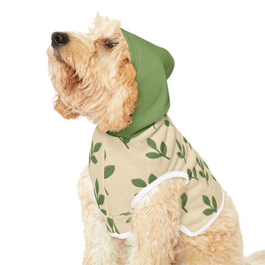 Dog wearing a green hooded outfit with leaf pattern on a white background