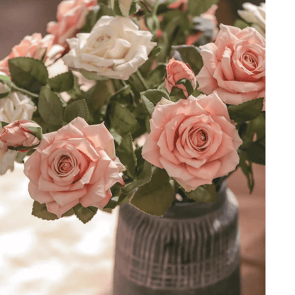 Bouquet of pink and white roses in a textured vase with a blurred background