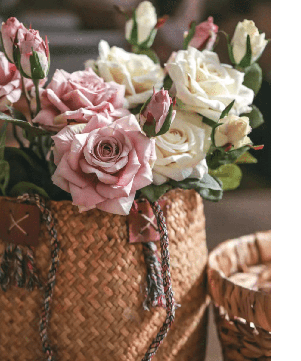 Bouquet of pink and white roses in a woven basket with a blurred background