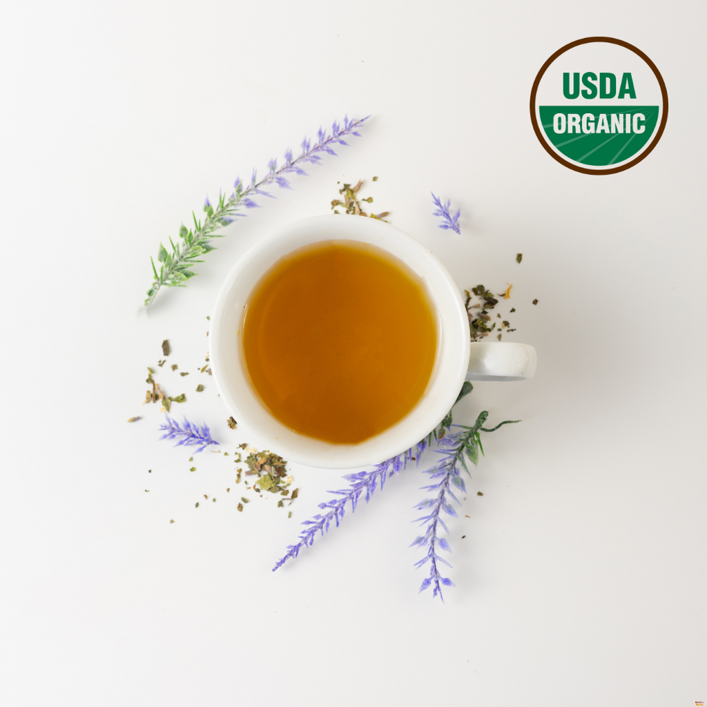 Tea cup with herbs and flowers on a white background, featuring the USDA Organic logo.
