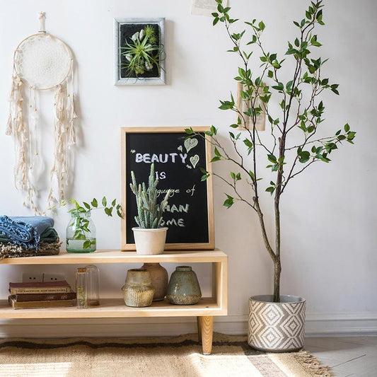Living room with a wooden shelf, decorative plants, and a framed quote on a white wall.