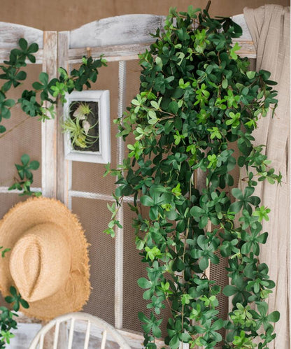 Decorative greenery with a straw hat on a wooden surface