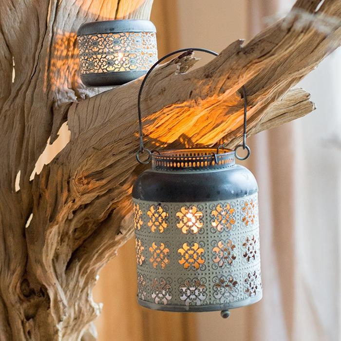 Decorative lantern with intricate patterns hanging from a branch