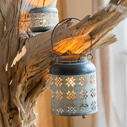 Decorative lantern with intricate patterns hanging from a branch